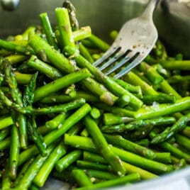 Sautéed asparagus in a silver skillet.