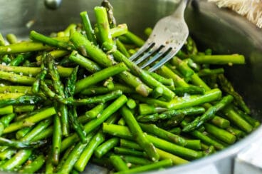 Sautéed asparagus in a silver skillet.