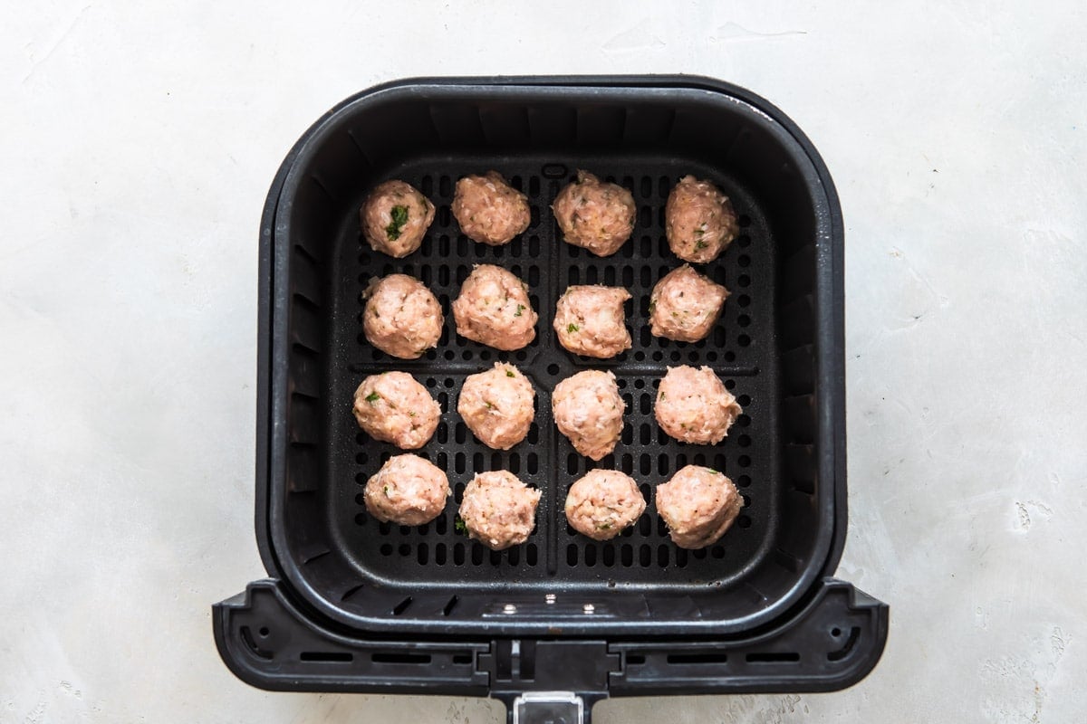 Sixteen meatballs in an air fryer.