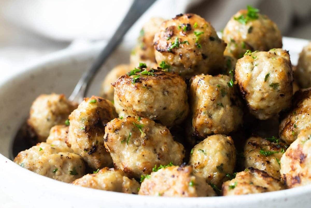 Air fryer meatballs in a white serving bowl.