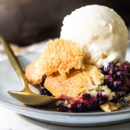 A plate of blackberry cobbler with vanilla ice cream.