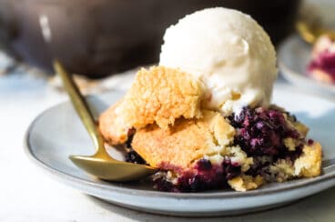 A plate of blackberry cobbler with vanilla ice cream.