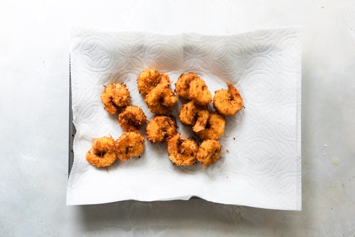 Coconut shrimp on a paper towel after being fried.