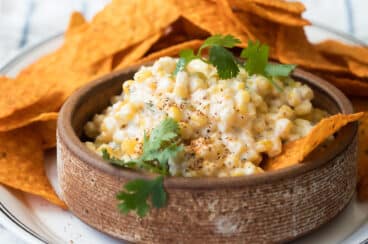 Mexican corn salad in a brown bowl.