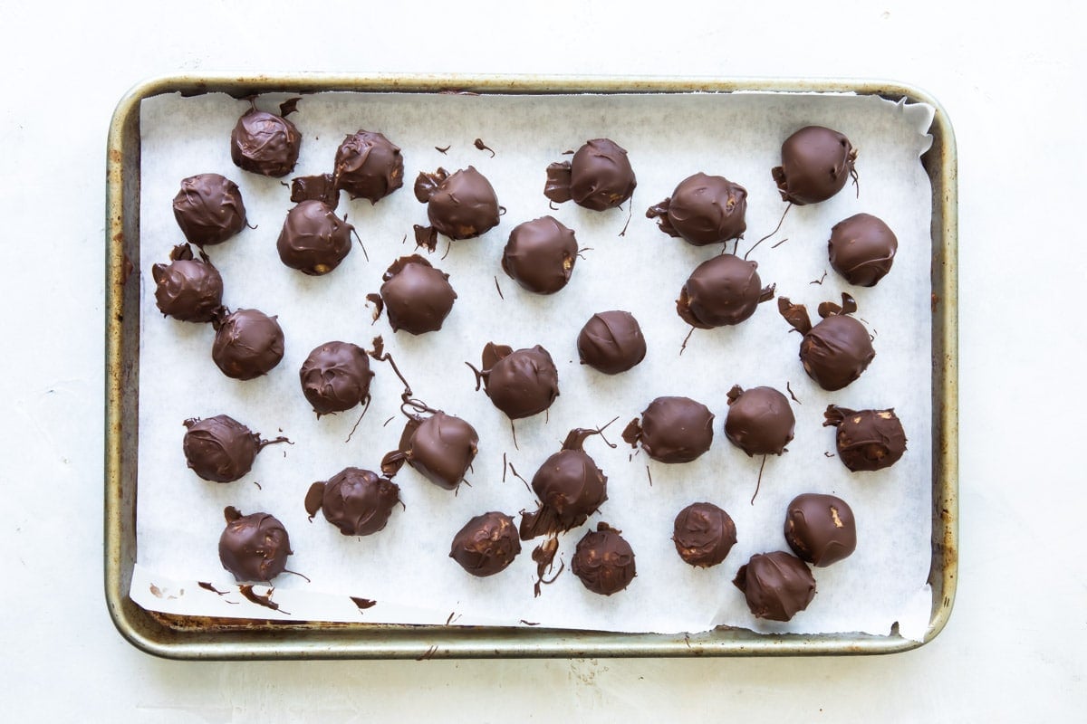 No bake peanut butter balls on a parchment paper lined baking sheet.