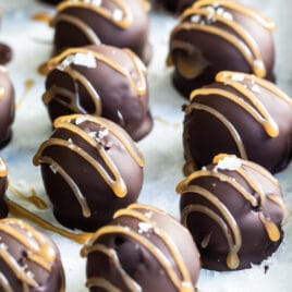 Oreo cookie balls on a parchment paper lined baking sheet.