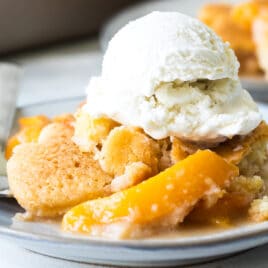 A plate of peach cobbler with vanilla ice cream.