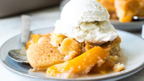 A plate of peach cobbler with vanilla ice cream.