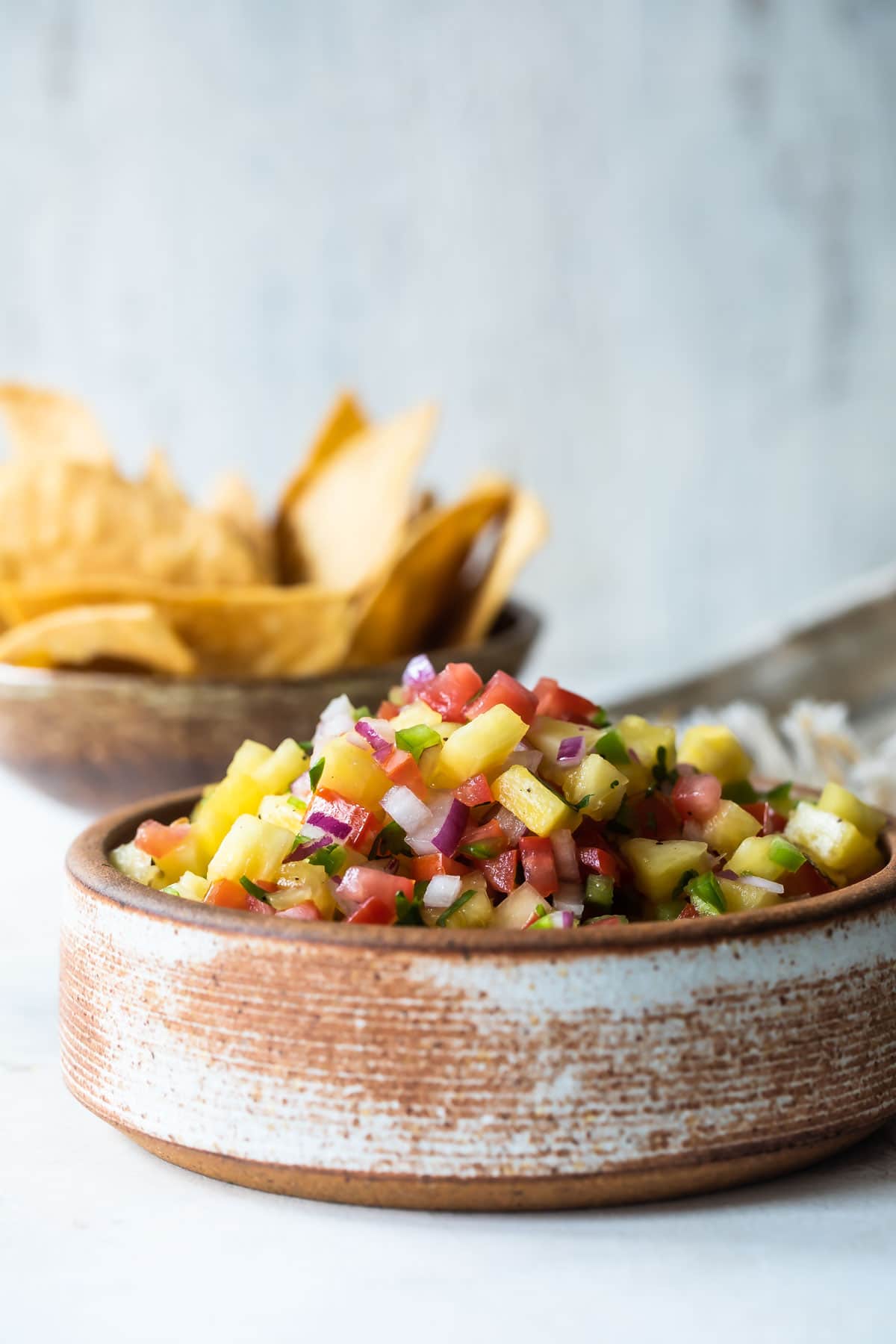 Pineapple salsa in a brown bowl.