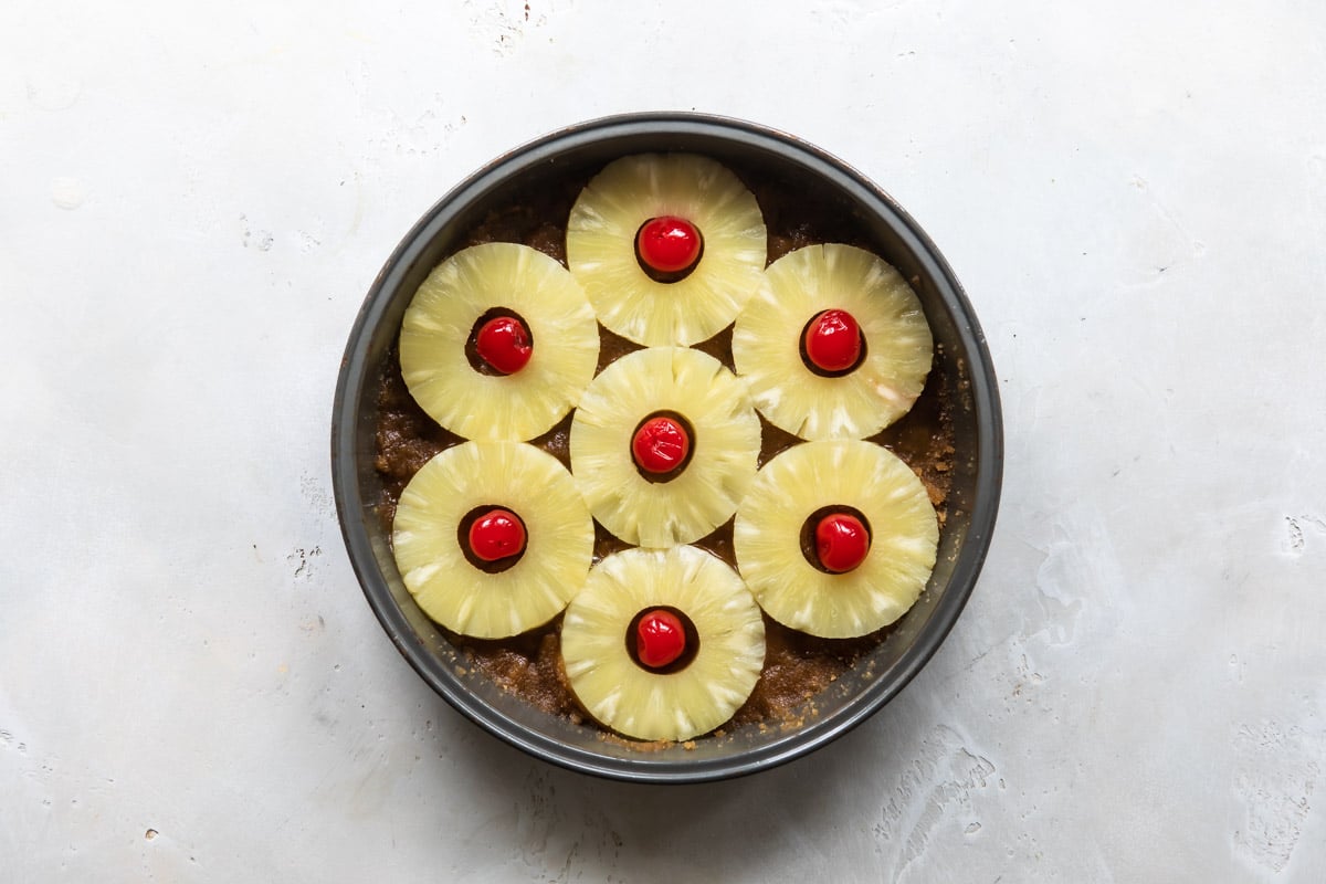 Pineapple and cherries in a cake pan.