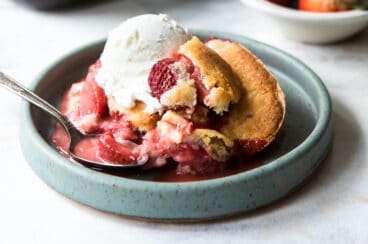 A dish of strawberry cobbler with ice cream.