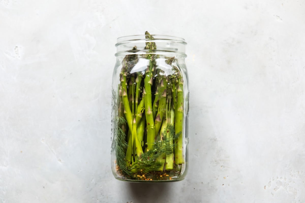 A jar of raw asparagus waiting to be pickled.