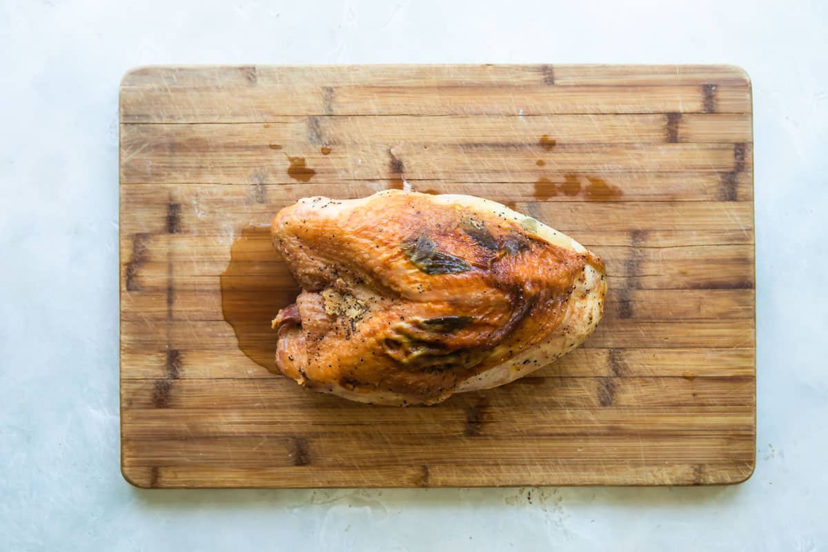 A roasted turkey breast on a cutting board.