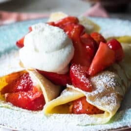Strawberry crepes on a blue plate.