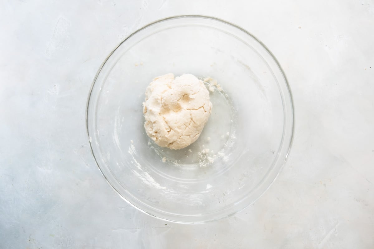 Biscuit dough in a clear bowl.