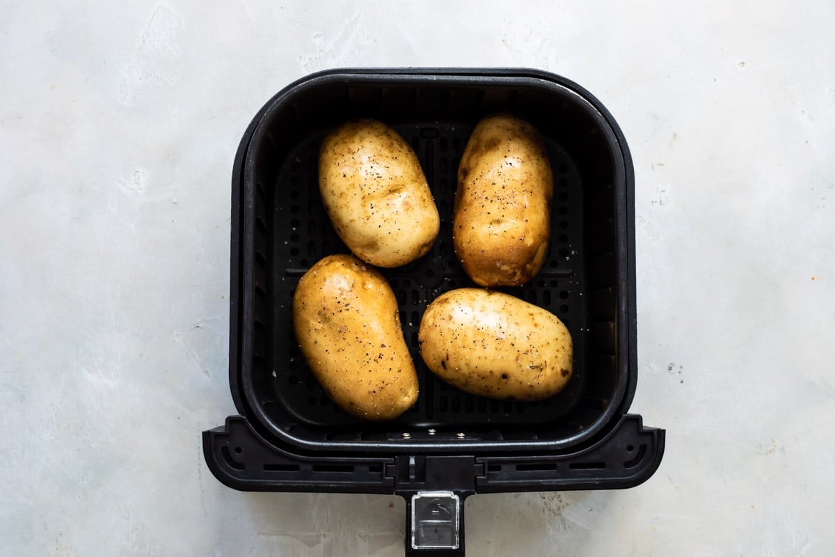 Raw potatoes in an air fryer.