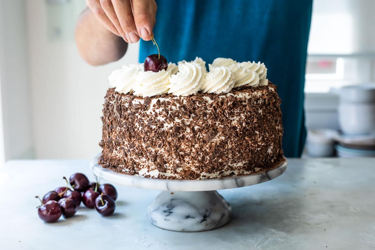 A frosted Black Forest Cake on a platter.