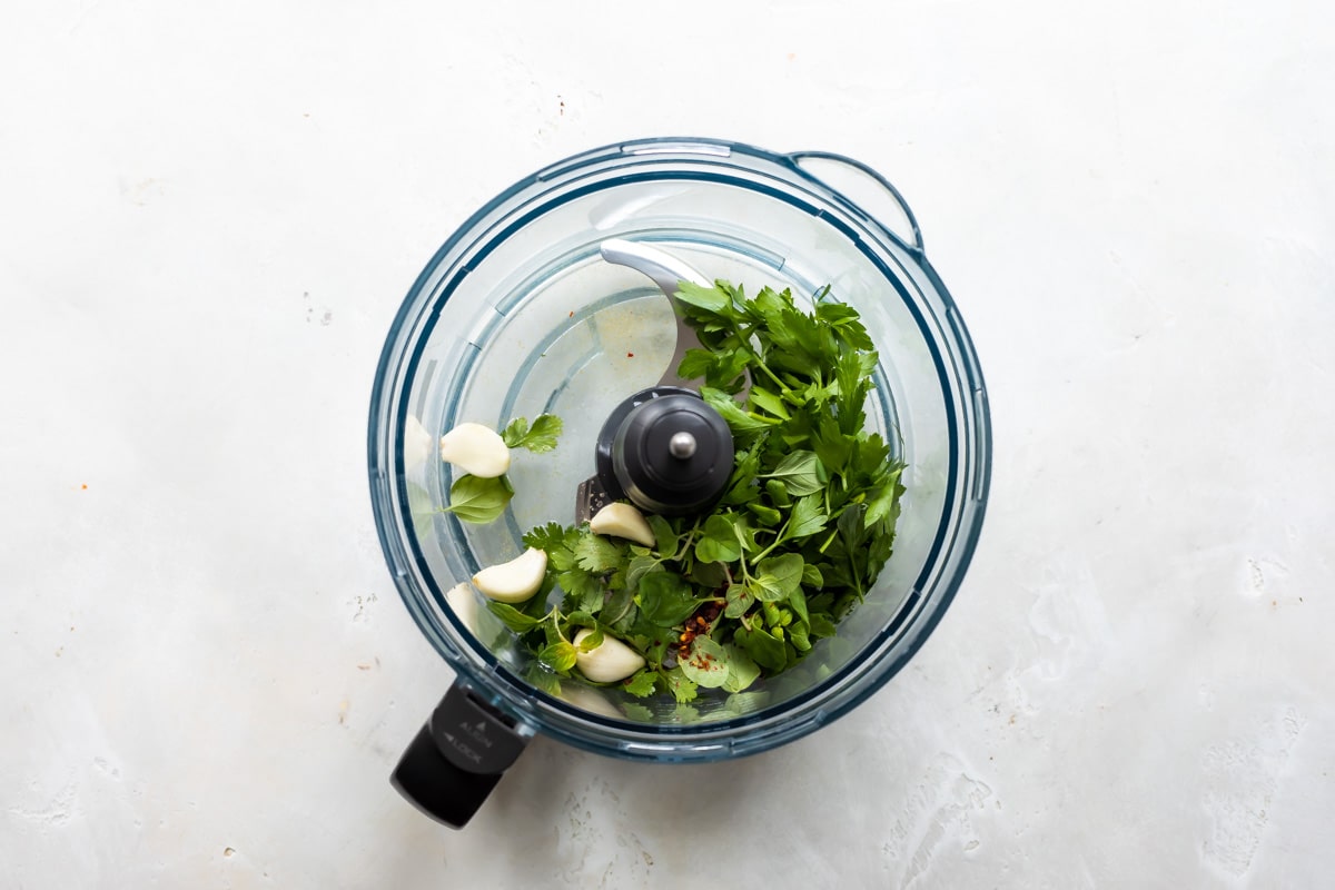 Ingredients for chimichurri sauce in a food processor.