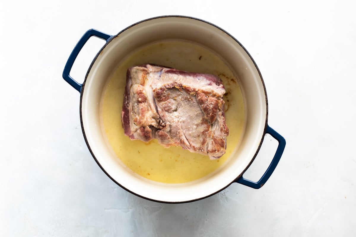 A cooked pork roast in a Dutch oven.