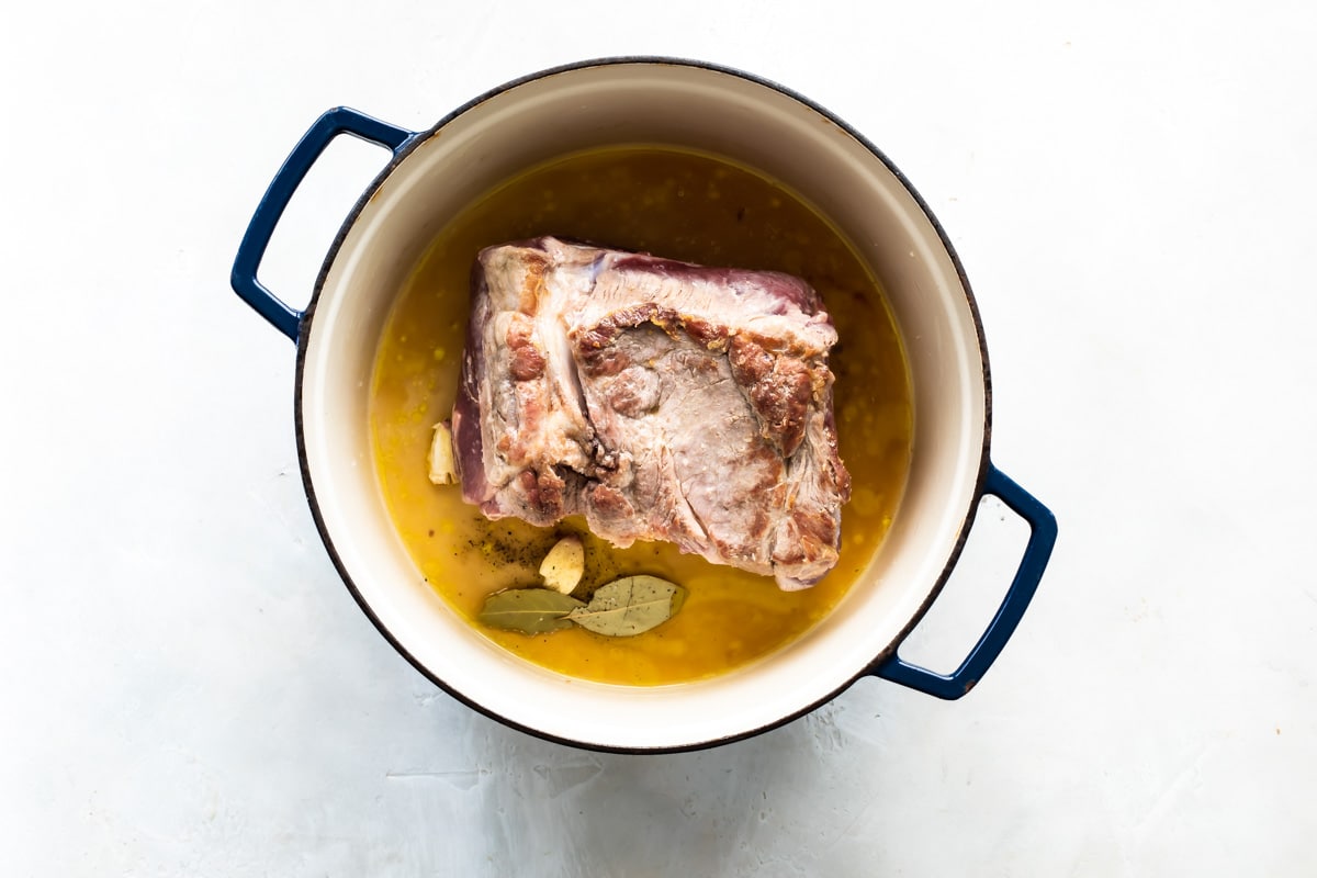 A cooked pork roast in a Dutch oven.