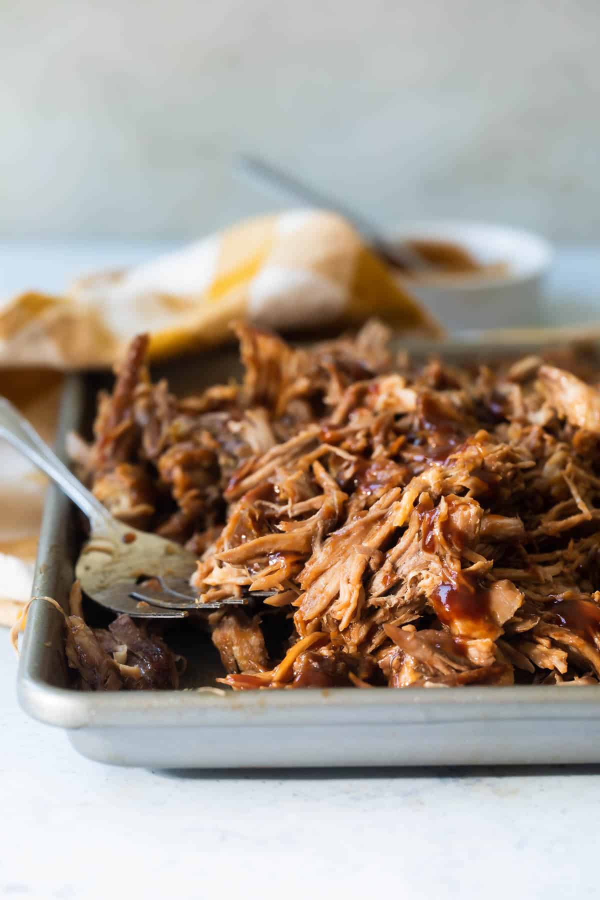A sheet pan of cooked pulled pork.