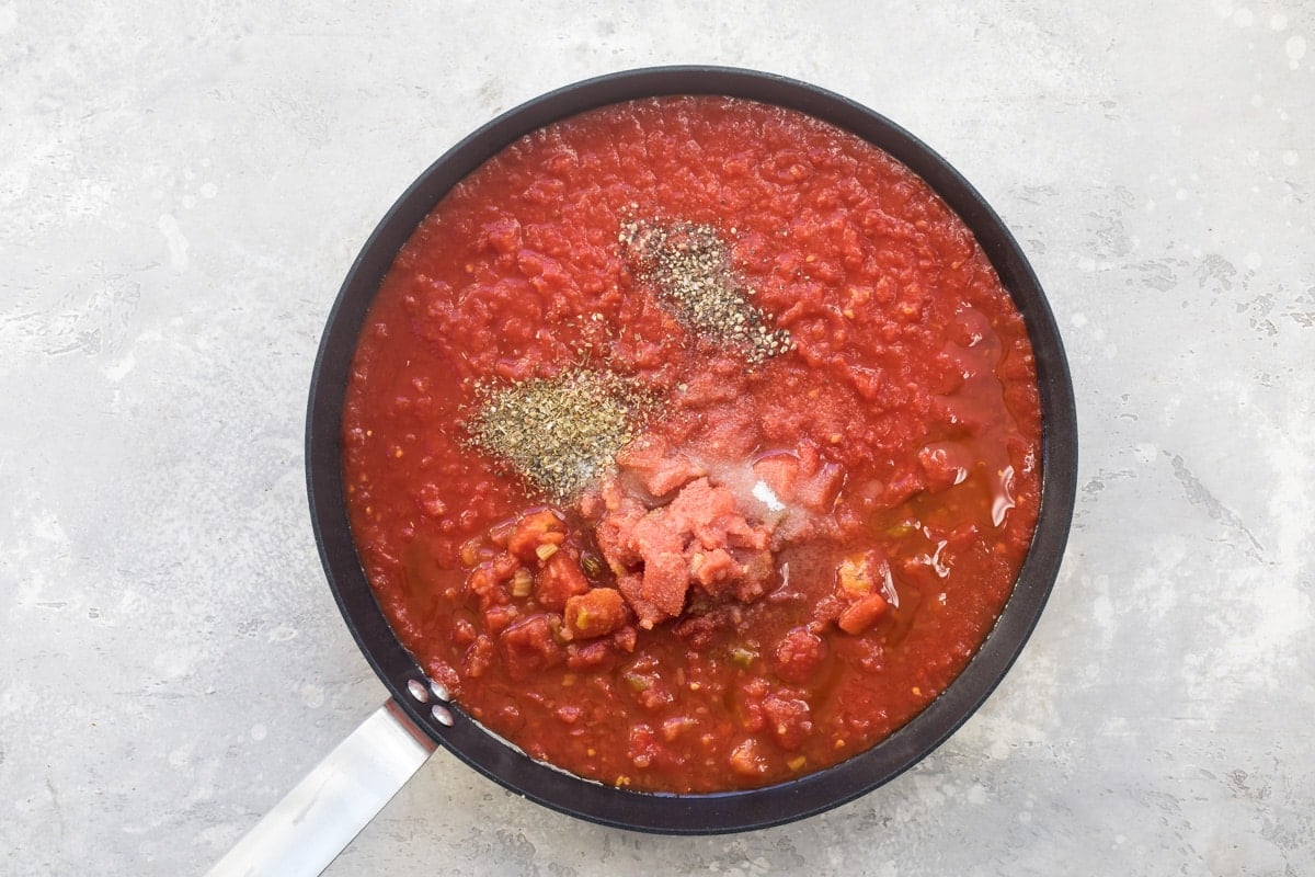 Tomato sauce cooking in a black skillet.