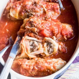 Stuffed cabbage rolls in a white baking dish.
