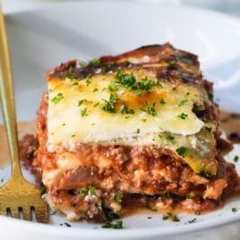 A slice of zucchini lasagna on a white plate.