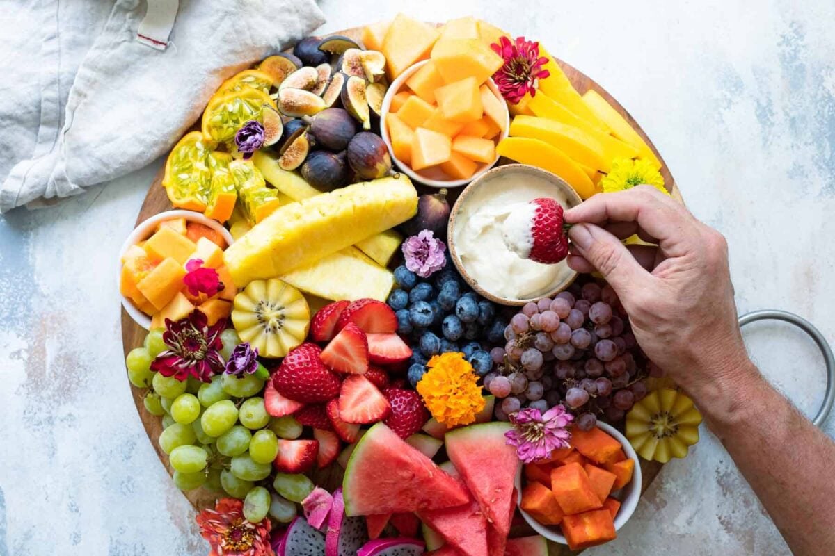 A platter of fresh fruit with fruit dip.