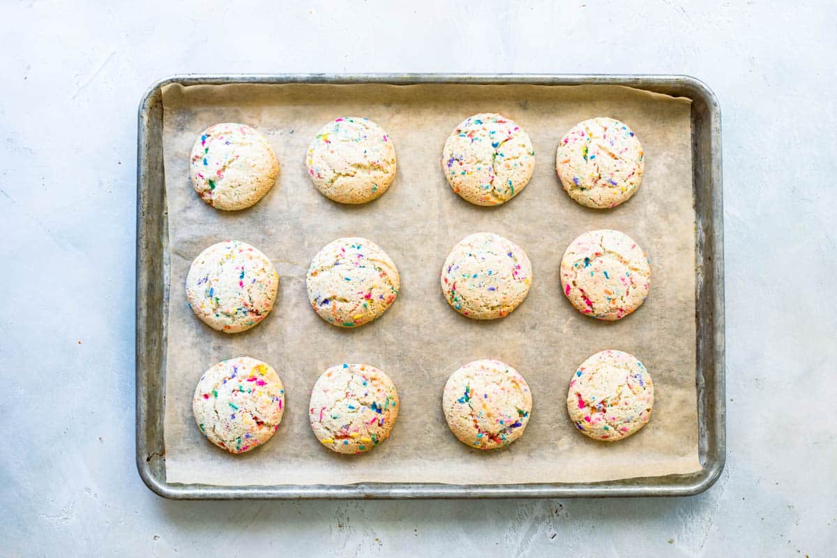 A baking sheet with funfetti cookies on it.