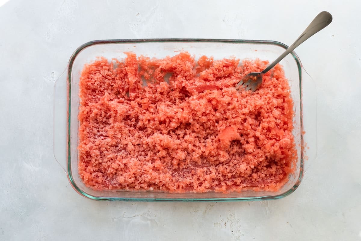 Scraping watermelon-flavored granita after freezing.