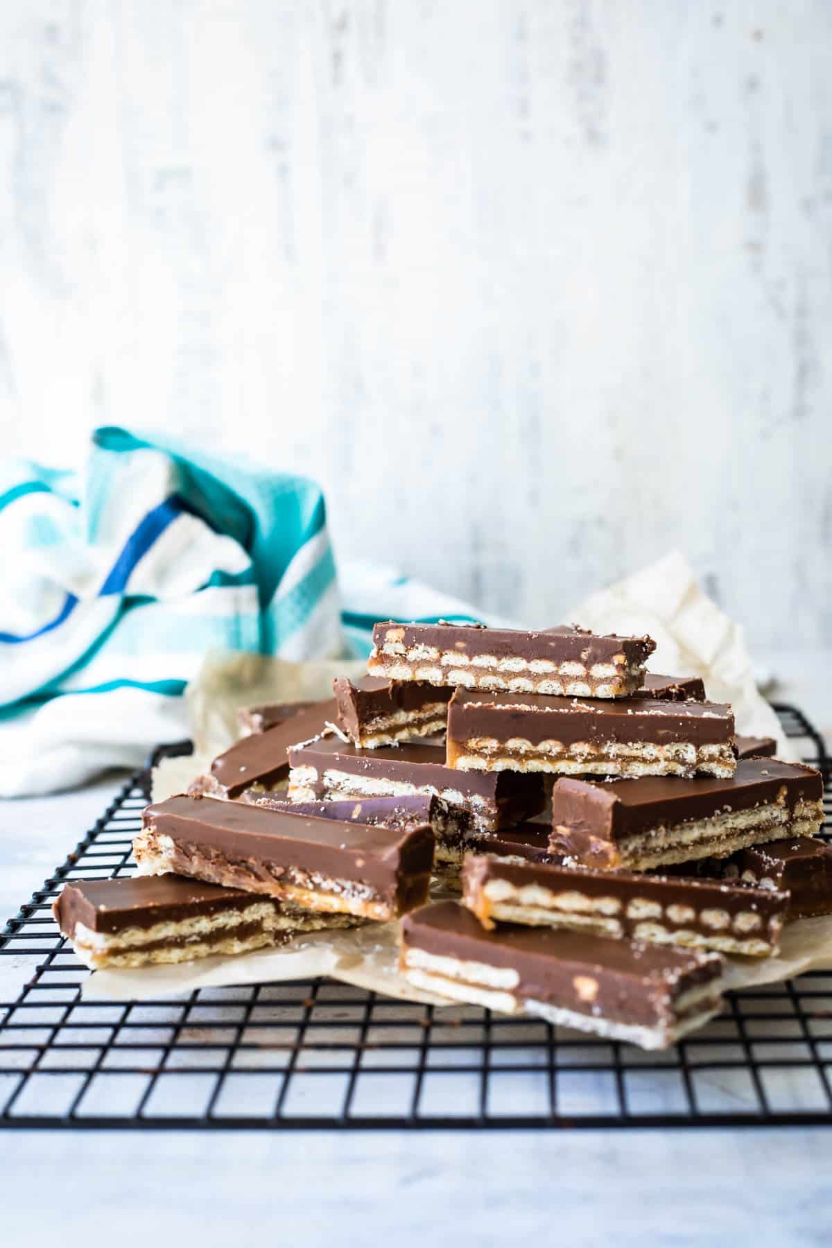 A cooling rack filled with neat slices of homemade twix bars.