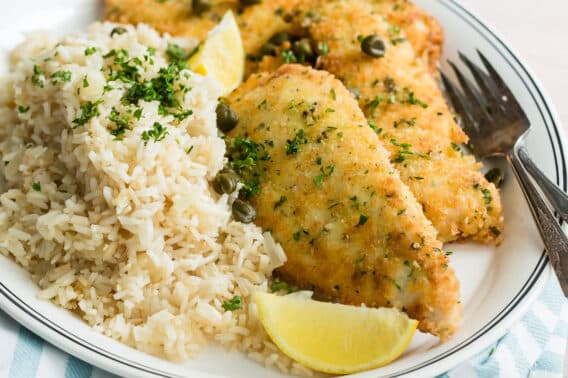 Lemon rice pilaf and chicken piccata on a platter.