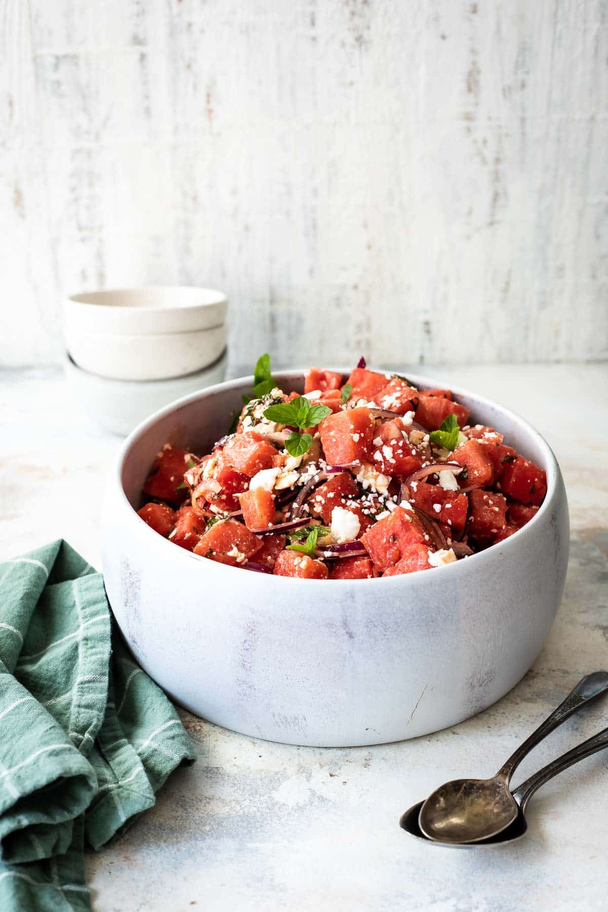 A marble serving bowl filled with Watermelon Salad.