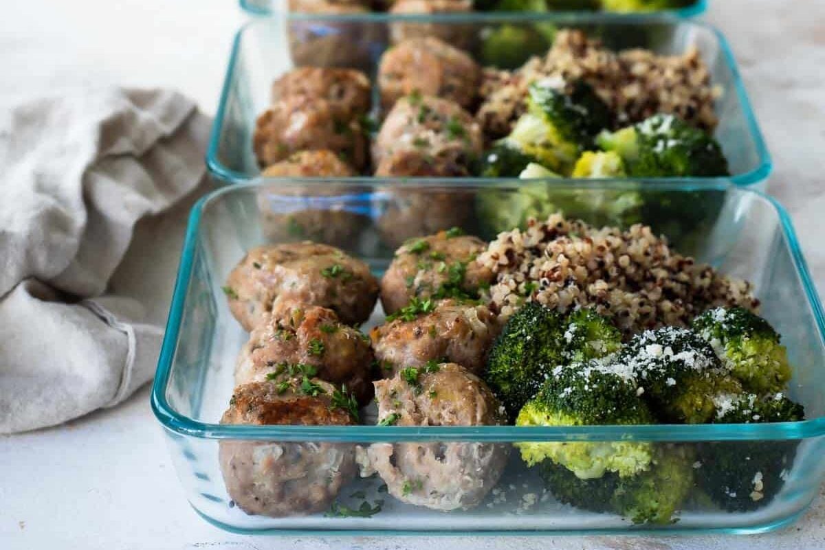 4 meal prep containers of turkey meatballs, quinoa, and roasted broccoli.