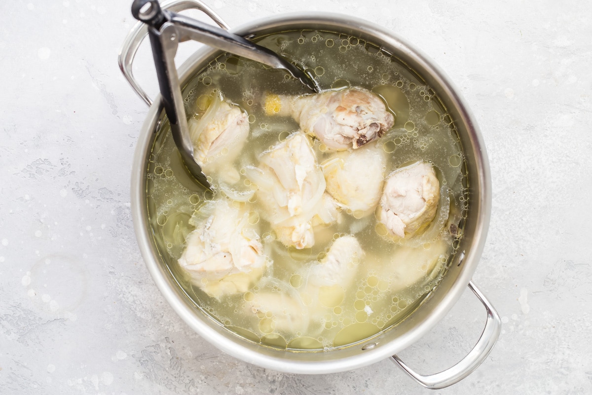 Chicken poaching in a stock pot.