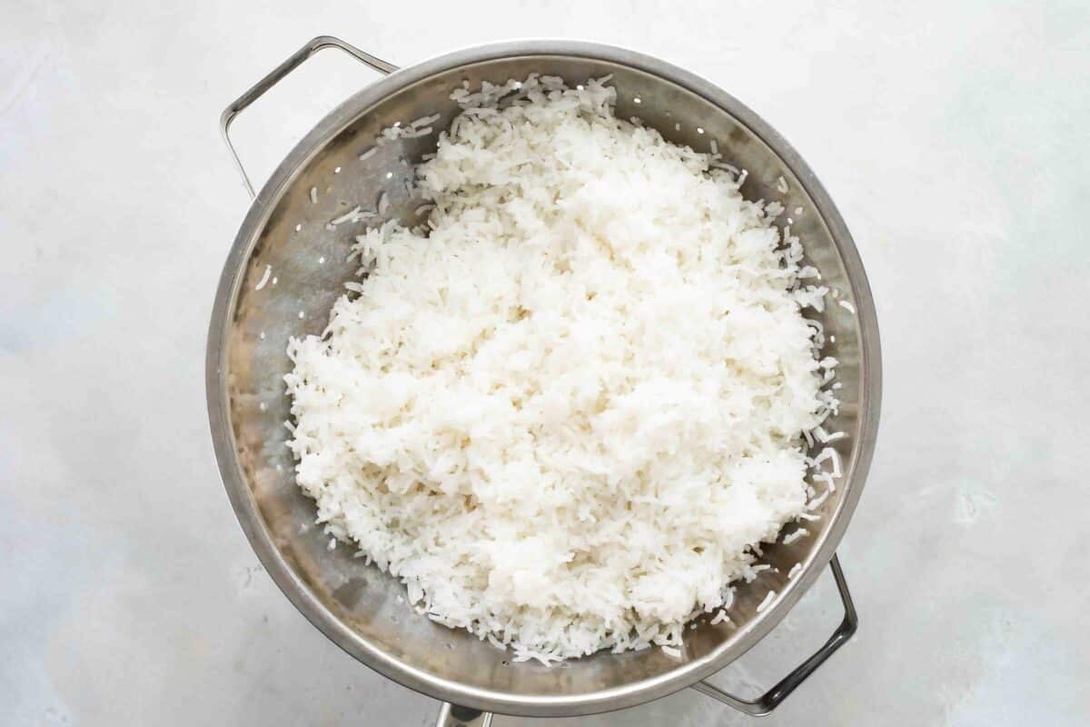 Cooked rice in a strainer.