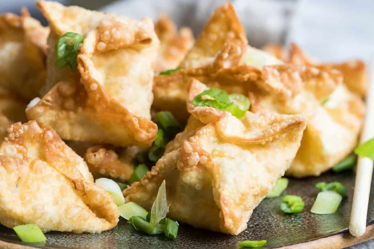 Cream cheese wontons on a brown plate.