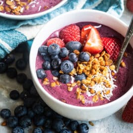 An easy acai bowl topped with coconut, nuts, and berries.
