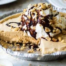 Peanut Butter pie in a silver pie pan with one piece removed.