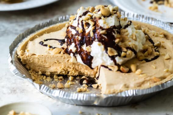Peanut Butter pie in a silver pie pan with one piece removed.