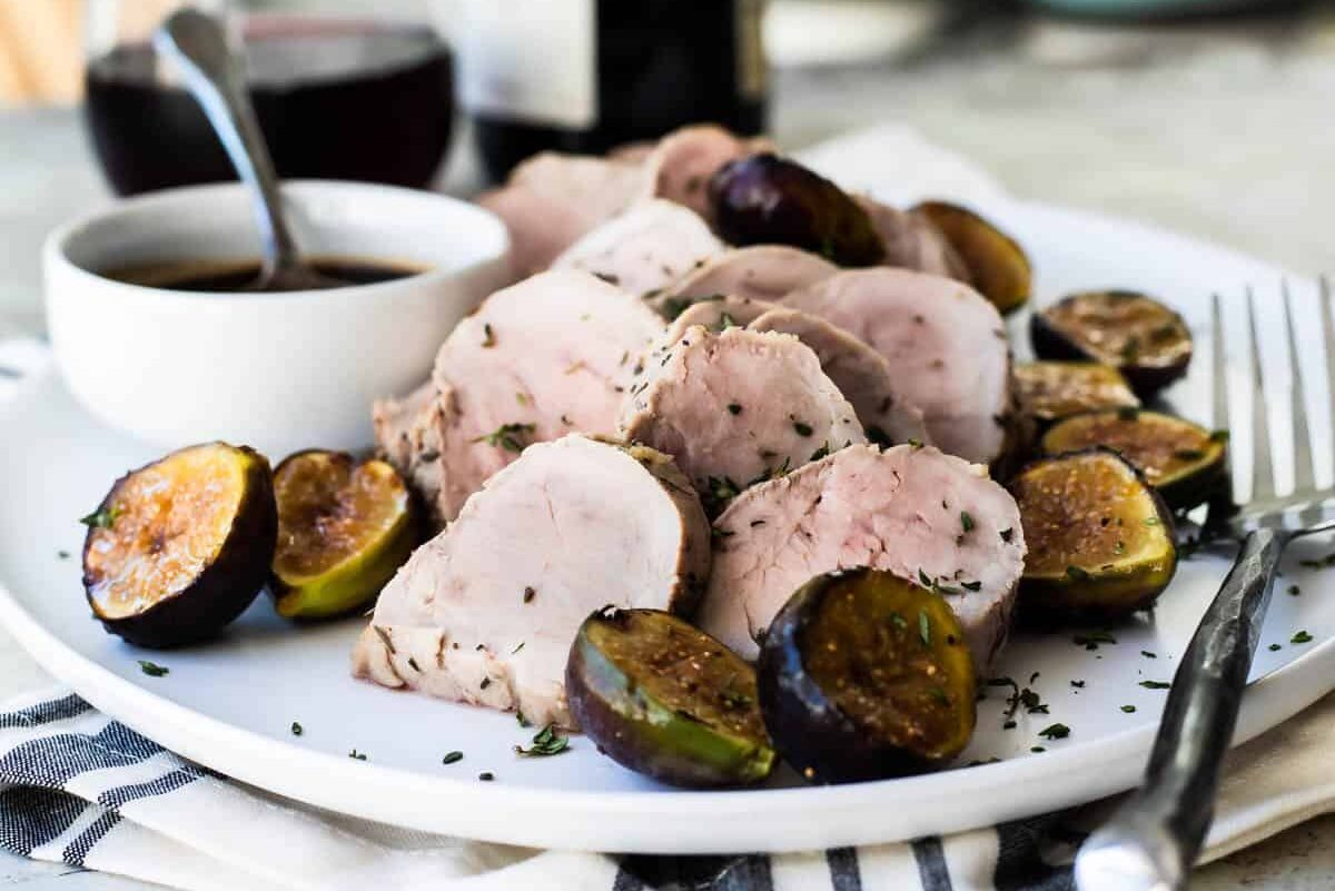 A plate with pork tenderloin with figs.