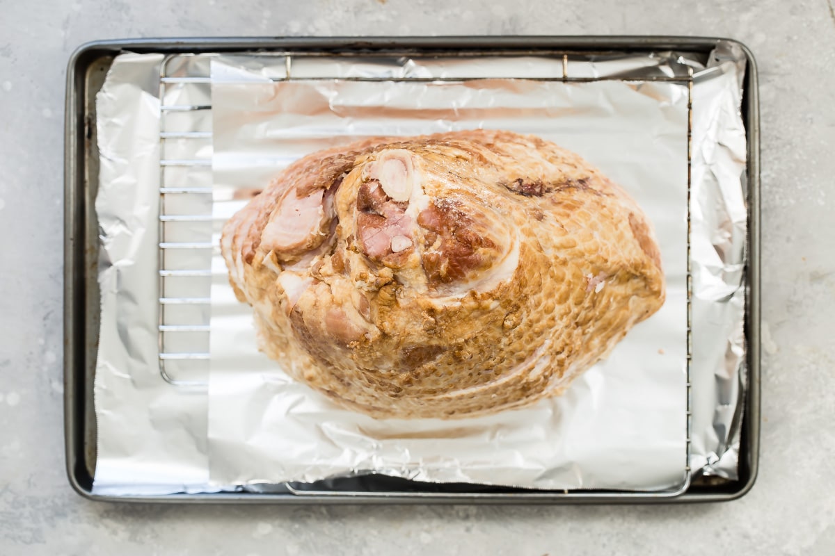 A smoked ham on a baking sheet.