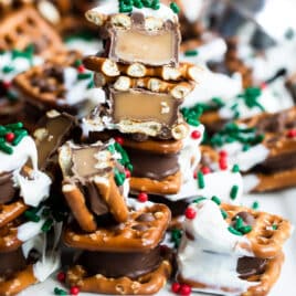 Rolo pretzel candies on a tray with Christmas sprinkles.