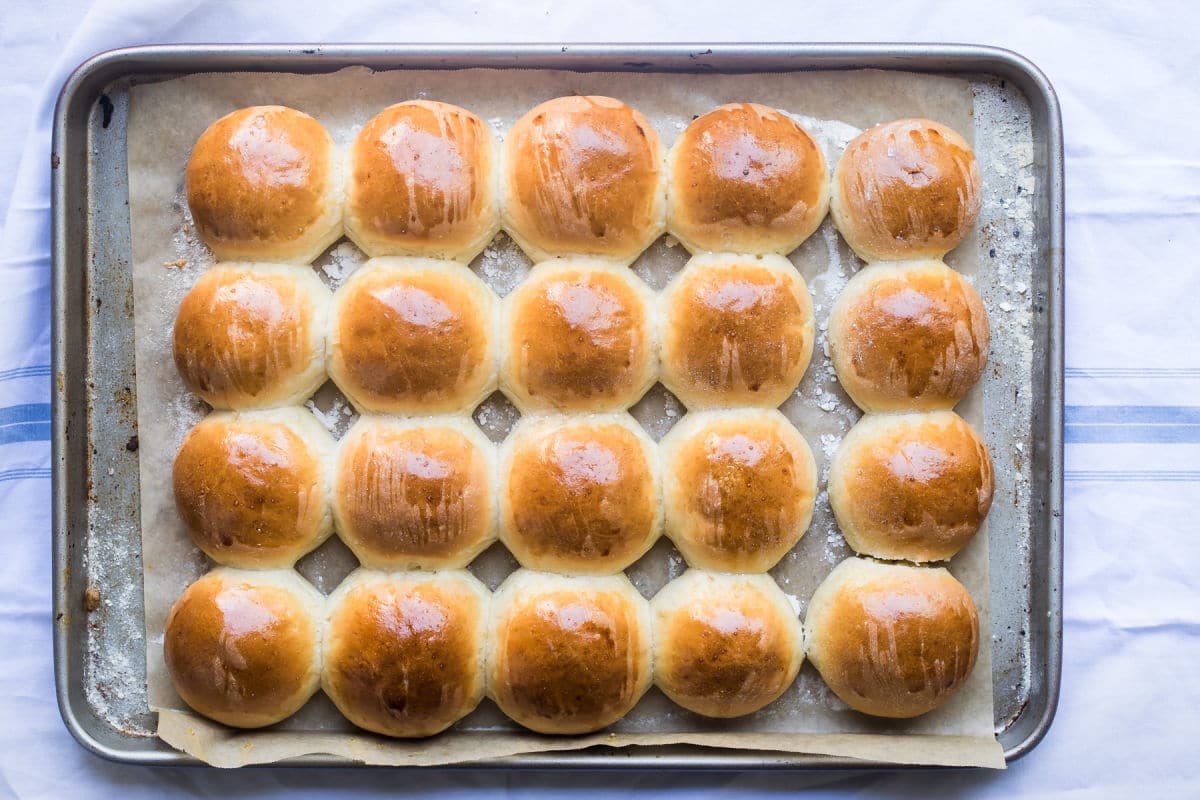 Baked dinner rolls on a baking sheet.