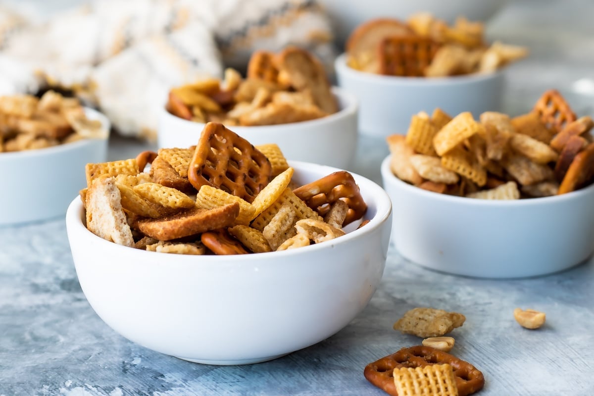 Bowls of chex mix on a gray background.