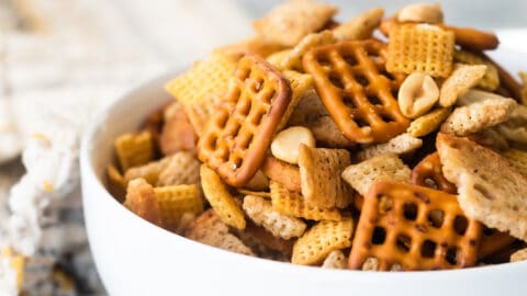 A bowl of Chex mix on a gray background.