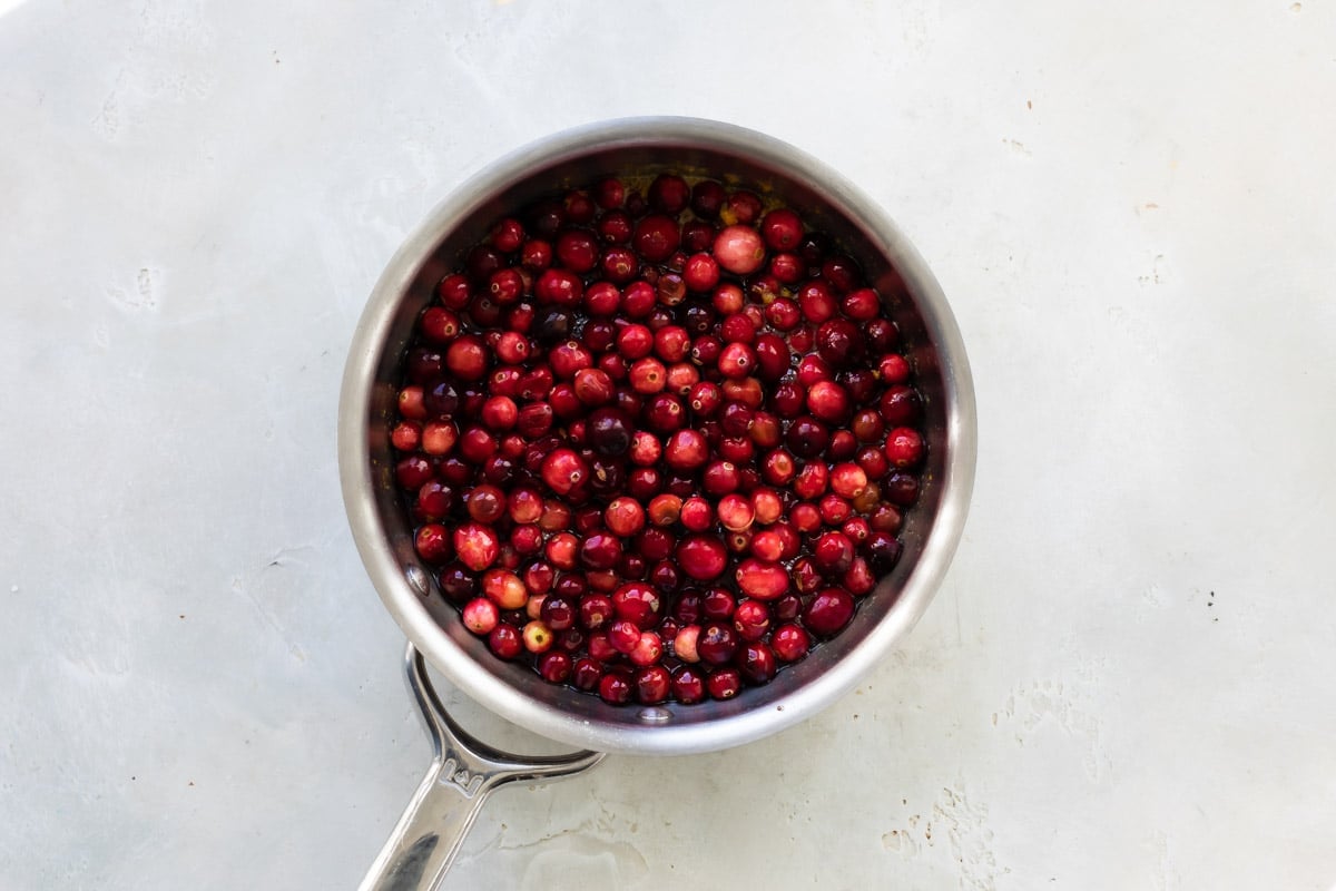 Making cranberry sauce in a small pot.