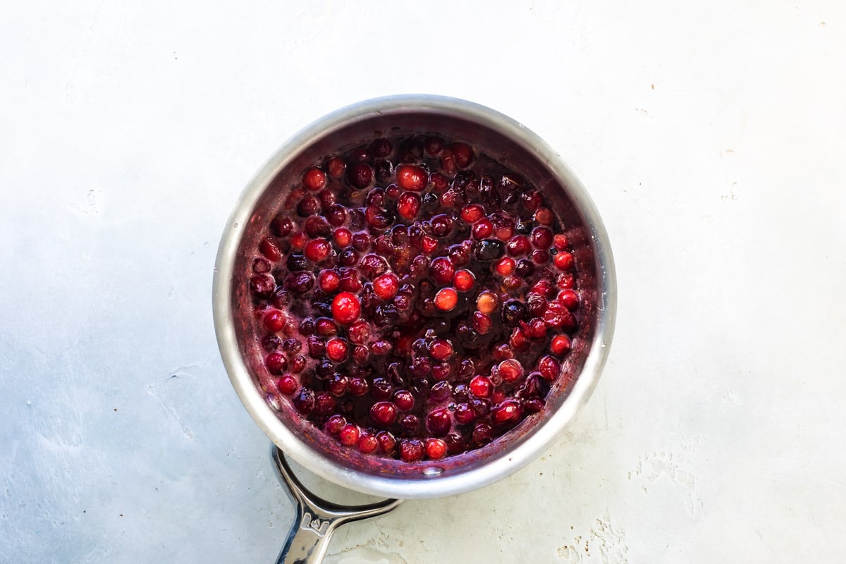 Making cranberry sauce in a small pot.
