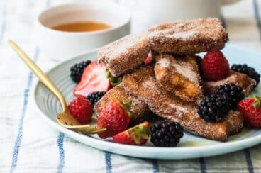 French Toast Sticks on a plate garnished with berries.